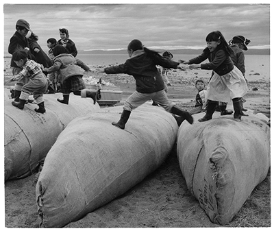 Enfants jouant sur des canots bonds de la Compagnie de la Baie d'Hudson